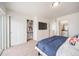 Bright bedroom with a walk-in closet, flat-screen TV, and access to an ensuite bathroom at 13029 E 103Rd Pl, Commerce City, CO 80022