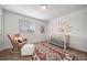 Bright Bedroom with a crib, rocking chair, and a sunny wall decal at 13029 E 103Rd Pl, Commerce City, CO 80022