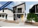 Modern two-story home featuring a balcony, black and gray siding, white trim, and a yellow front door at 13029 E 103Rd Pl, Commerce City, CO 80022