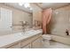 Functional bathroom has bathtub with shower, vanity with white countertop, and floral wallpaper at 9954 W Progress Pl, Littleton, CO 80123