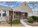Charming brick home featuring a cozy front porch, manicured landscaping, and inviting curb appeal at 9954 W Progress Pl, Littleton, CO 80123