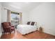 Cozy bedroom with a full bed, patterned armchair, and natural light from the sliding glass doors at 7440 S Blackhawk St # 14-208, Englewood, CO 80112