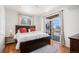 Bright bedroom with a large bed, accent pillows, a window, and sliding glass doors to a balcony at 7440 S Blackhawk St # 14-208, Englewood, CO 80112