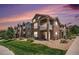 Beautiful multi-story condo building with stone accents, private balconies, and well-manicured lawn at 7440 S Blackhawk St # 14-208, Englewood, CO 80112