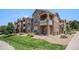 Multi-story condo building shows stone accents, private balconies, and well-manicured lawn at 7440 S Blackhawk St # 14-208, Englewood, CO 80112