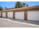 Attached garages with white doors and brown siding provide convenient parking at 7440 S Blackhawk St # 14-208, Englewood, CO 80112