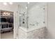 Updated tile shower featuring a bench, glass enclosure, and multiple shower heads, and access to walk-in closet at 12467 Topaz Vista Way, Castle Pines, CO 80108