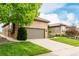 Lovely home featuring stone accents, attached garage, concrete driveway, and manicured lawn at 12467 Topaz Vista Way, Castle Pines, CO 80108