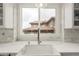 Bright kitchen featuring a white farmhouse sink, marble countertops, and natural light from the window at 12467 Topaz Vista Way, Castle Pines, CO 80108