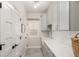 Functional laundry room features a farmhouse sink, quartz countertops, and ample storage cabinets at 12467 Topaz Vista Way, Castle Pines, CO 80108