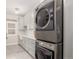 Modern laundry room with stacked washer and dryer and shaker style cabinets at 12467 Topaz Vista Way, Castle Pines, CO 80108