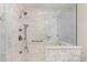 Luxurious walk-in shower with marble tile, rainfall showerhead, and built-in bench at 12467 Topaz Vista Way, Castle Pines, CO 80108