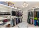 Spacious walk-in closet with custom shelving, hanging rods, and ample storage for clothing and accessories at 12467 Topaz Vista Way, Castle Pines, CO 80108