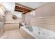 Bathroom featuring a soaking tub, sink with vanity, and exposed ceiling at 1430 Mount Evans Dr, Longmont, CO 80504