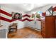 Bedroom with hardwood floors, large window, and stylish red and white chevron accent wall at 1430 Mount Evans Dr, Longmont, CO 80504