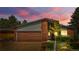 Well-maintained single Gathering house with a two-car garage and manicured front yard at dusk at 1430 Mount Evans Dr, Longmont, CO 80504