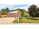 Charming single-Gathering home featuring brick accents, a well-manicured lawn, and an attached garage at 1430 Mount Evans Dr, Longmont, CO 80504