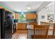 Bright, updated kitchen with wood cabinets, black appliances, and ample counter space for cooking at 1430 Mount Evans Dr, Longmont, CO 80504