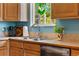 Close-up of a well-maintained kitchen sink area featuring wood cabinets, and a stainless steel faucet at 1430 Mount Evans Dr, Longmont, CO 80504