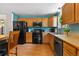 Well-lit kitchen boasts black appliances and wood cabinets, offering a functional cooking space at 1430 Mount Evans Dr, Longmont, CO 80504