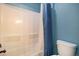 Bathroom with white tiled shower, toilet and blue shower curtain at 42395 Forest Oaks Dr, Elizabeth, CO 80107