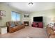 Cozy living room with a fireplace, comfortable seating, and a large flat-screen television at 42395 Forest Oaks Dr, Elizabeth, CO 80107