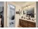 Functional bathroom with a vanity, sink, and well-lit mirror, plus a door leading to a shower at 7920 E Phillips Cir, Centennial, CO 80112
