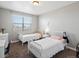 Neutral bedroom with two twin beds, a large window, and soft natural light creating a comfortable space at 14077 Indianfield Ct, Hudson, CO 80642