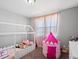 Bedroom featuring a play tent, unique canopy bed frame and plush carpeting at 14077 Indianfield Ct, Hudson, CO 80642