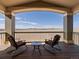 Covered deck features outdoor seating and expansive views of the surrounding landscape at 14077 Indianfield Ct, Hudson, CO 80642