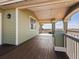 Covered deck area with wood floors and green siding at 14077 Indianfield Ct, Hudson, CO 80642