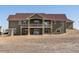 Exterior of a two-story home showcasing a covered balcony and a large backyard at 14077 Indianfield Ct, Hudson, CO 80642