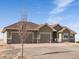 Beautiful single-story home with three-car garage, stone accents and a spacious driveway on a sunny day at 14077 Indianfield Ct, Hudson, CO 80642