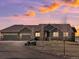 Stunning exterior view of a home with a three-car garage at dusk with a beautiful colorful sunset sky at 14077 Indianfield Ct, Hudson, CO 80642