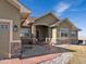 Inviting front entrance featuring a covered porch, stone accents, and a well-manicured walkway leading to the front door at 14077 Indianfield Ct, Hudson, CO 80642