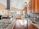 Spacious kitchen with granite countertops, stainless steel appliances, and a large island with cooktop and sink at 14077 Indianfield Ct, Hudson, CO 80642