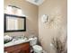 Stylish powder room with granite countertop, decorative mirror, modern lighting, and elegant wall decor at 14077 Indianfield Ct, Hudson, CO 80642