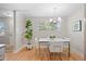 Dining area featuring a stylish table, four chairs, a modern chandelier, and a large plant at 717 E 4Th Ave, Longmont, CO 80504