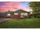 Charming brick home with a wooden ramp and well-maintained lawn against a beautiful sunset sky at 717 E 4Th Ave, Longmont, CO 80504