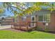 Charming brick home featuring a wooden ramp, close up on entrance and beautiful front lawn at 717 E 4Th Ave, Longmont, CO 80504