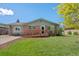 Charming brick home featuring a wooden ramp for accessibility and a well-manicured front yard at 717 E 4Th Ave, Longmont, CO 80504