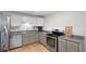 Well-lit kitchen with stainless steel appliances, light cabinets, and hardwood floors at 717 E 4Th Ave, Longmont, CO 80504