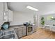 A kitchen with stainless steel appliances, modern cabinetry, and hardwood floors leading to the dining room at 717 E 4Th Ave, Longmont, CO 80504