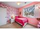 Bedroom featuring pink walls with floral accent wallpaper and a bright window at 8035 Lee Dr # 1, Arvada, CO 80005