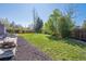 Expansive backyard featuring a manicured lawn, mature trees, and a patio area with outdoor seating at 8004 S Field St, Littleton, CO 80128