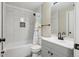 Bathroom featuring tiled walls, gray vanity with black hardware, and a shower/tub combo at 8004 S Field St, Littleton, CO 80128