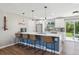 Modern kitchen features a breakfast bar, white cabinets, stainless steel appliances and hardwood floors at 8004 S Field St, Littleton, CO 80128