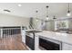 Modern open-concept kitchen with breakfast bar, white cabinets, and stainless steel appliances at 8004 S Field St, Littleton, CO 80128
