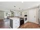 Modern open-concept kitchen with breakfast bar, white cabinets, and stainless steel appliances at 8004 S Field St, Littleton, CO 80128