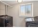 Efficient laundry room with modern black appliances and a window offering natural light at 8004 S Field St, Littleton, CO 80128